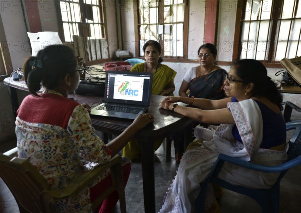Officials checks the documents submitted by people at an National Register of Citizens (NRC) Seva