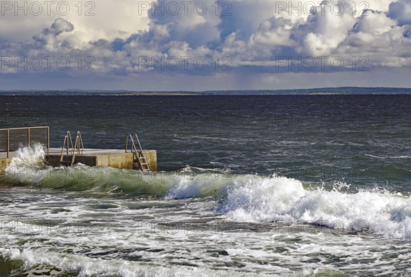 Huge waves crash against a jetty under a dramatic sky, Tönsberg, Oslofjord, Norway, Europe