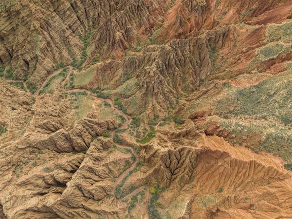 Eroded mountain landscape, top-down, canyon with red and orange rock formations, aerial view,