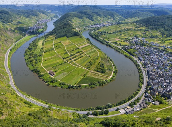 A winding river bend surrounds an agricultural landscape surrounded by hills, with a neighbouring