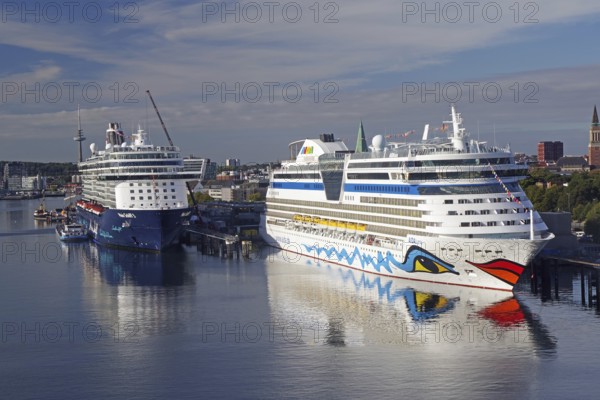 Two large cruise ships in a quiet harbour, with water and city in the background, Aida, Mein