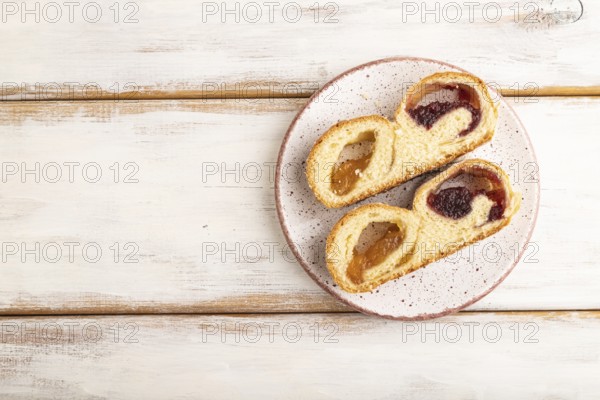 Homemade sweet bun with apricot jam on white wooden background. top view, flat lay, copy space