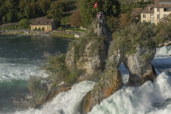 Rhine Falls seen from Laufen Castle, rocky island, Swiss flag, spray, watermill, Canton Zurich, on