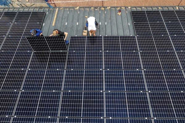 Installation of solar modules on the roof of a barn on a farm, over 210 photovoltaic modules are