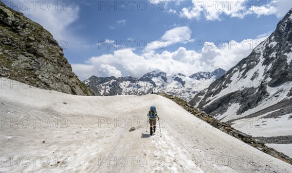 Mountaineer hiking in a snowfield, Nördliche Mörchnerscharte, behind mountain peak Greizer Spitze