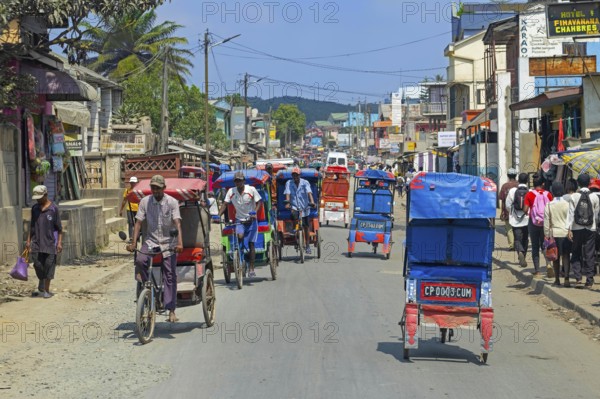 Cycle rickshaws, cyclo-pousses, velotaxis in bust street in the city Moramanga, Alaotra-Mangoro