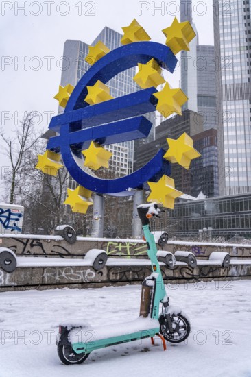 Winter in Frankfurt, euro sculpture on Willy-Brandt-Platz, snow-covered, e-scooter, Hesse, Germany,