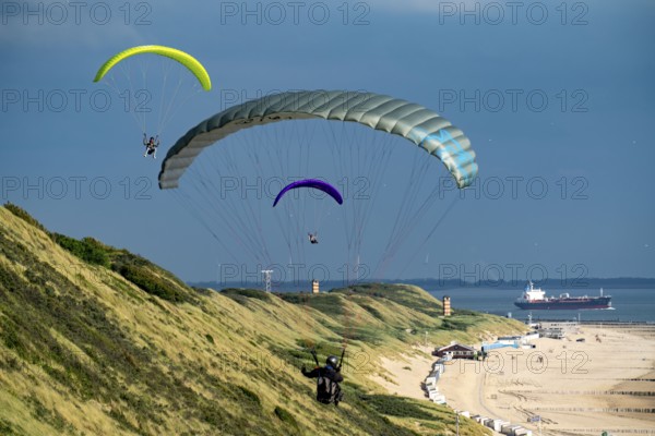 Paragliders along the dunes of Zoutelande, in Zeeland, South Holland, Netherlands