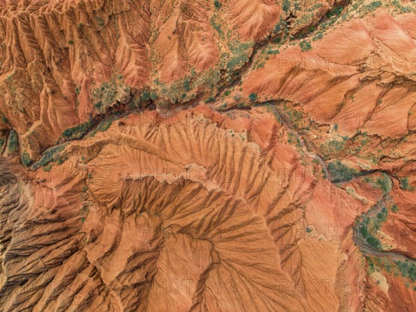 Eroded mountain landscape, top-down, canyon with red and orange rock formations, aerial view,