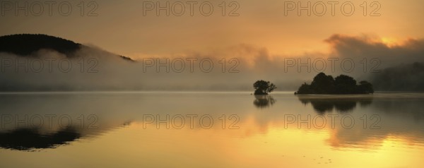 Sunrise at the Edersee with morning mist on the water, small islands in the Edertalsperre,