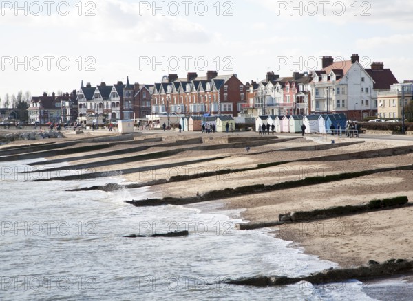 Sandy beach concrete groyne sea defences and historic buildings on the seafront on a sunny day in