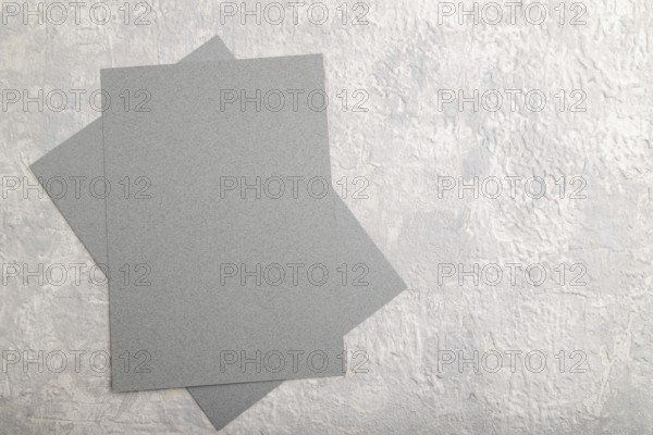 Gray paper business card, mockup on gray concrete background. Blank, flat lay, top view, still