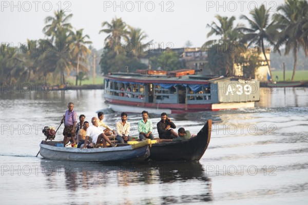 Indian men travelling on a motorboat, canal system of the backwaters, Kerala, India, Asia