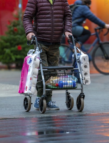 Man with rollator buys 2 large packs of toilet paper, The city centre of Bochum, on the day of the