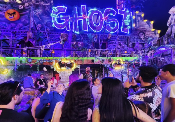 People in front of the illuminated ghost train Ghost in the evening, Cranger Kirmes, Herne, Ruhr