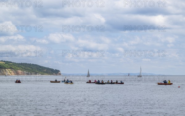 People in a canoe on Seaton Bay with the Haven Cliffs Naturist Beach in the background, Jurassic
