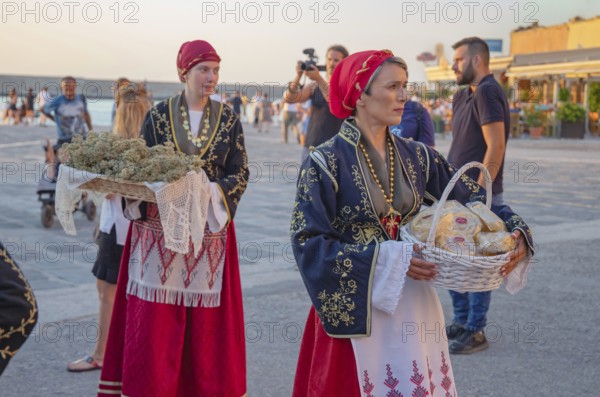 Traditionally dressed Greek women carrying gifts during marriage celebration, Chania, Crete, Greek
