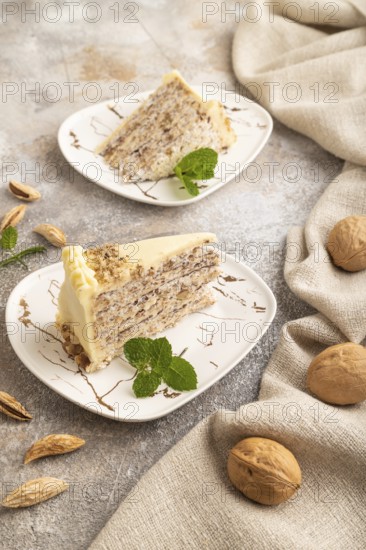 Walnut and almond cake on brown concrete background and linen textile. side view, close up