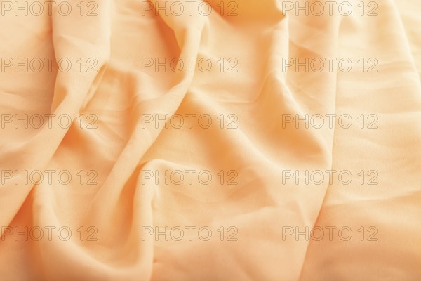 Fragment of orange linen tissue. Side view, natural textile background and texture. wave concept,