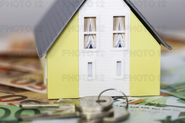 Concept photo with model house, euro notes and coins