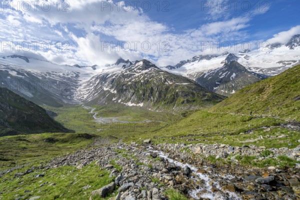 Picturesque mountain landscape with mountain stream, mountain peaks with snow and glacier