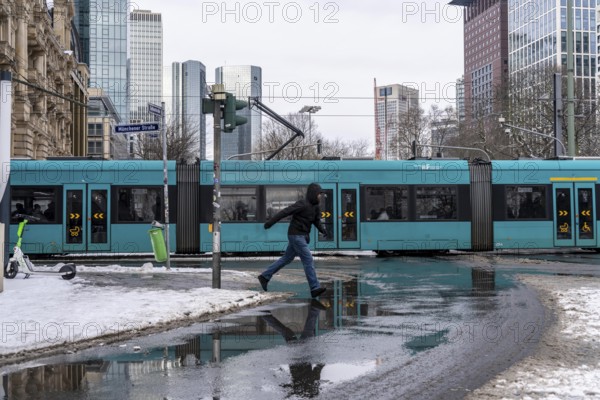 Winter in the city, Gallusanlage street, puddles, pools of water, melt water, pedestrians,