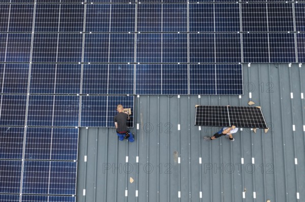Installation of solar modules on the roof of a barn on a farm, over 210 photovoltaic modules are