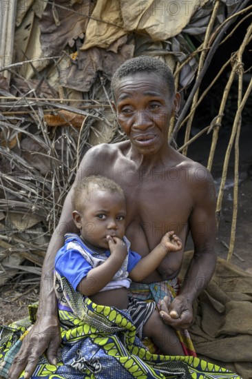 Pygmy woman of the Baka or BaAka people with her child in front of her hut, Bayanga, Sangha-Mbaéré