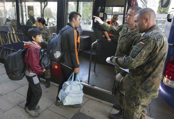 Syrian refugees arrive at Schönefeld station on a special train. They are then taken by bus to