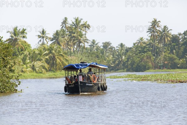 Traditional boat on a canal in the canal system of the backwaters, Kerala, India, Asia