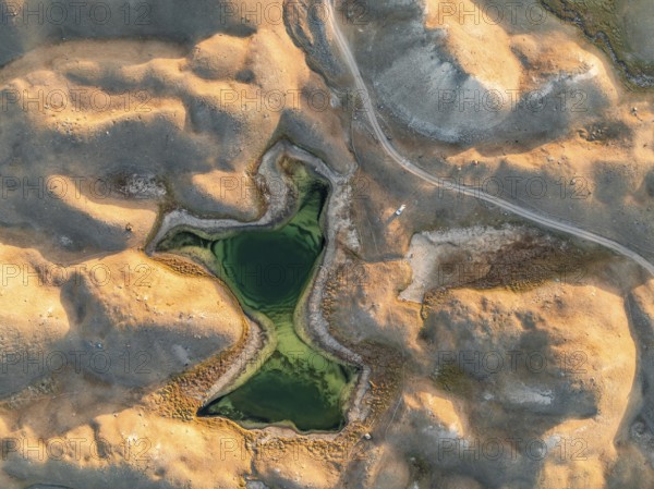 Green lakes between golden hills with gravel road, top down shot, aerial view, Trans Alay