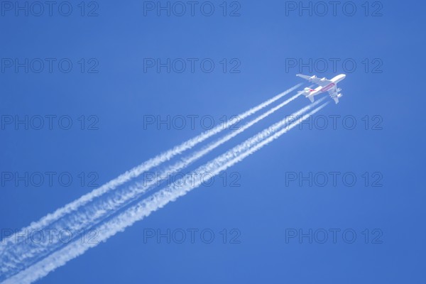 An Emirates Airbus A380-800 aircraft with registration number A6-EVN in flight with contrails over