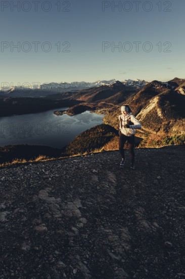 Trail running in autumn on the Jochberg on Lake Walchensee against the wonderful backdrop of the