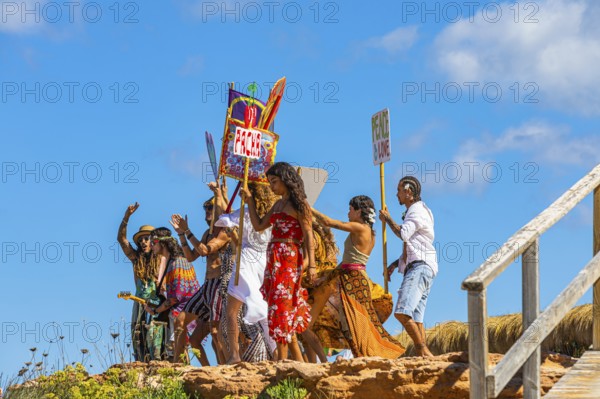 Colourfully dressed youths with musical instruments and banners form a love parade and promote the