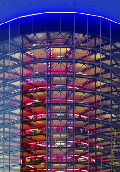 An illuminated car tower with new cars for delivery in the evening, Autostadt, Volkswagen AG,