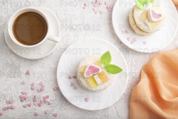 Decorated cake with milk and coconut cream with cup of coffee on a gray concrete background and