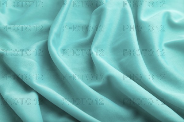 Fragment of silk blue tissue. Side view, natural textile background and texture. wave concept,