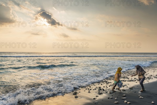 Muslim woman in the evening sun at Mangsit beach in Sengiggi, Islam, religion, headscarf, travel,