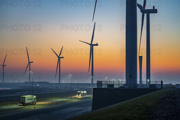 Lorry on the road from Euromax Terminal Rotterdam, ENECO wind farm on the dike around the port of