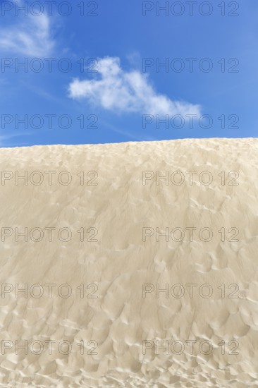 Empty dune, shifting dune, fine sand, spring clouds, minimalist landscape, symbolic image,