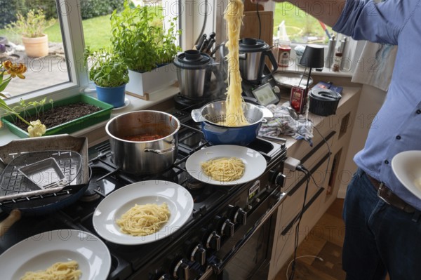 Lunch of a family, freshly cooked spaghetti is distributed on plates for the family, Bavaria,