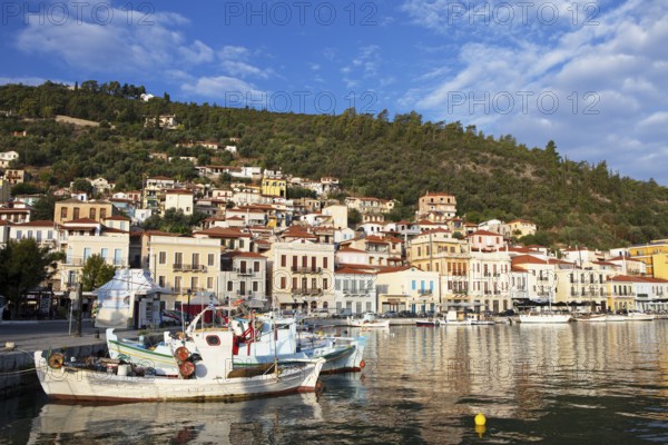 Small fishing boats in the Mediterranean harbour of Gythio or Gythion, behind houses and the