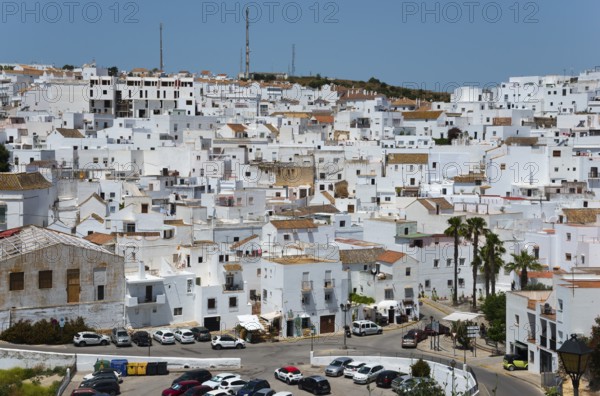 Panorama of a white town with narrow streets, parked cars and hilly surroundings, New Town, Vejer