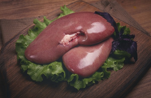 Raw pork kidneys, on a chopping board, close-up, top view, no people