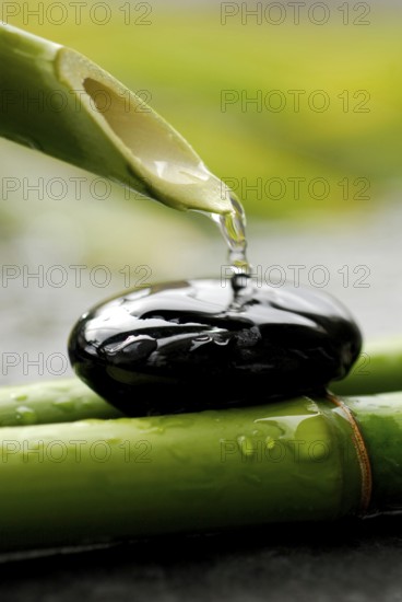 Water flows from bamboo cane, stone