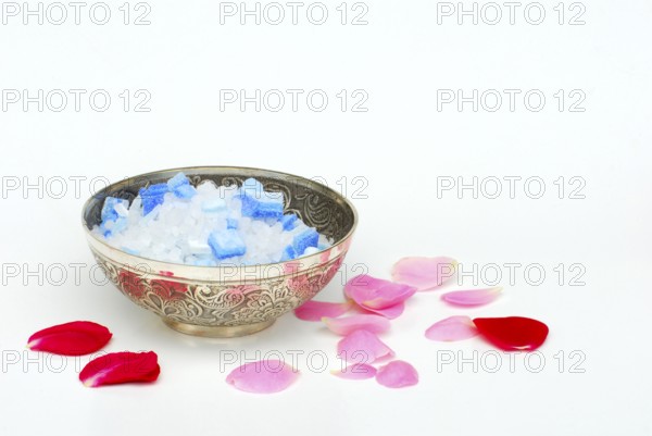 Bath salt in a bowl, rose petals