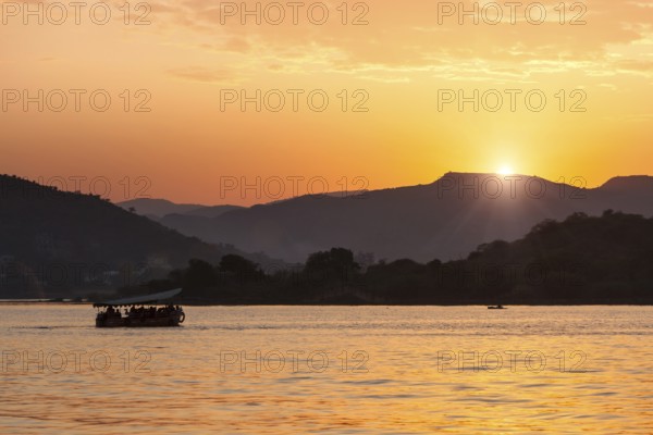 Tourist boat in lake Pichola on sunset. Udaipur, Rajasthan, India, Asia