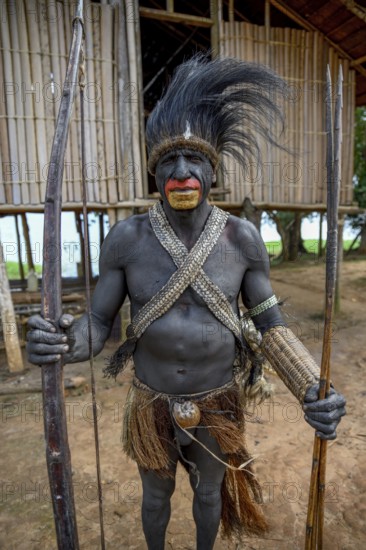Chief of the village Mutin with bow and arrow, Lake Murray, Western Province, Papua New Guinea,