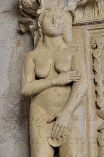 Eve with a fig leaf on the western gate of Trogir Cathedral or Cathedral of St. Lawrence, 13th
