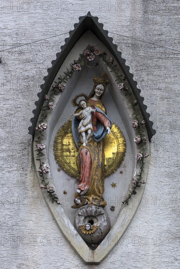 Sculpture of the Mother of God, Mary with the Child Jesus on a residential building facade,